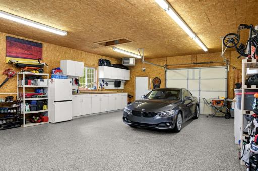Expansive heated 4-car garage with epoxy floors and double-sided access.