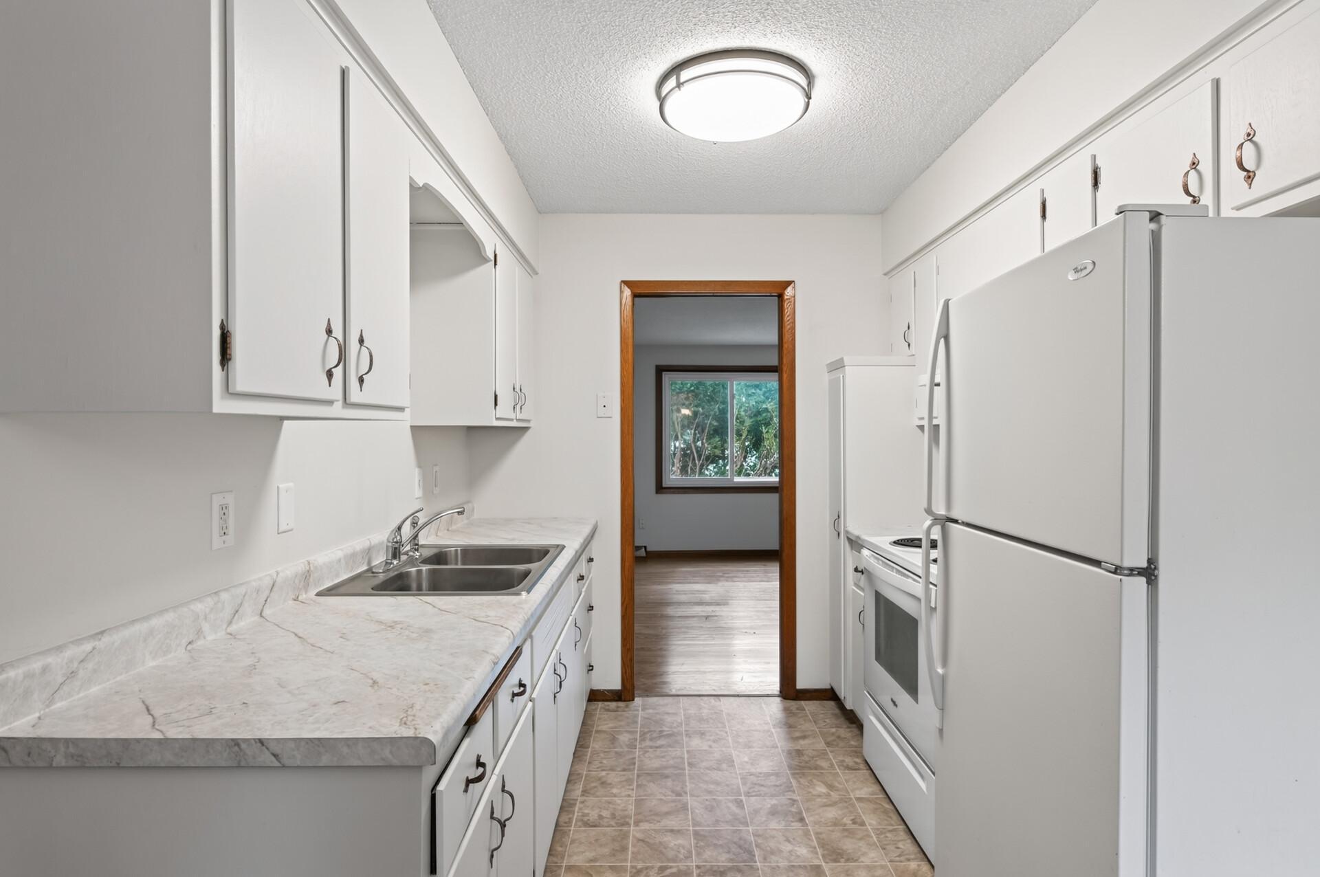 Kitchen features new countertops with a sleek, clean feel.