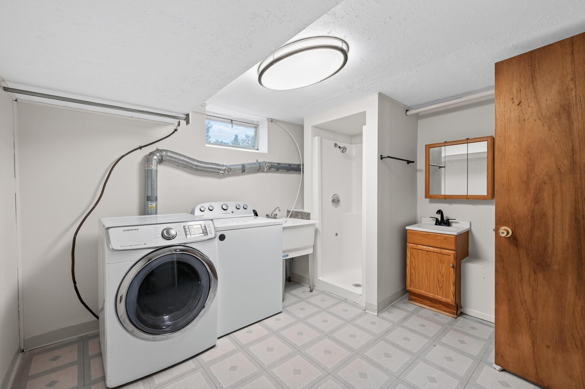 Laundry room with washer and dryer features a 2nd bathroom.