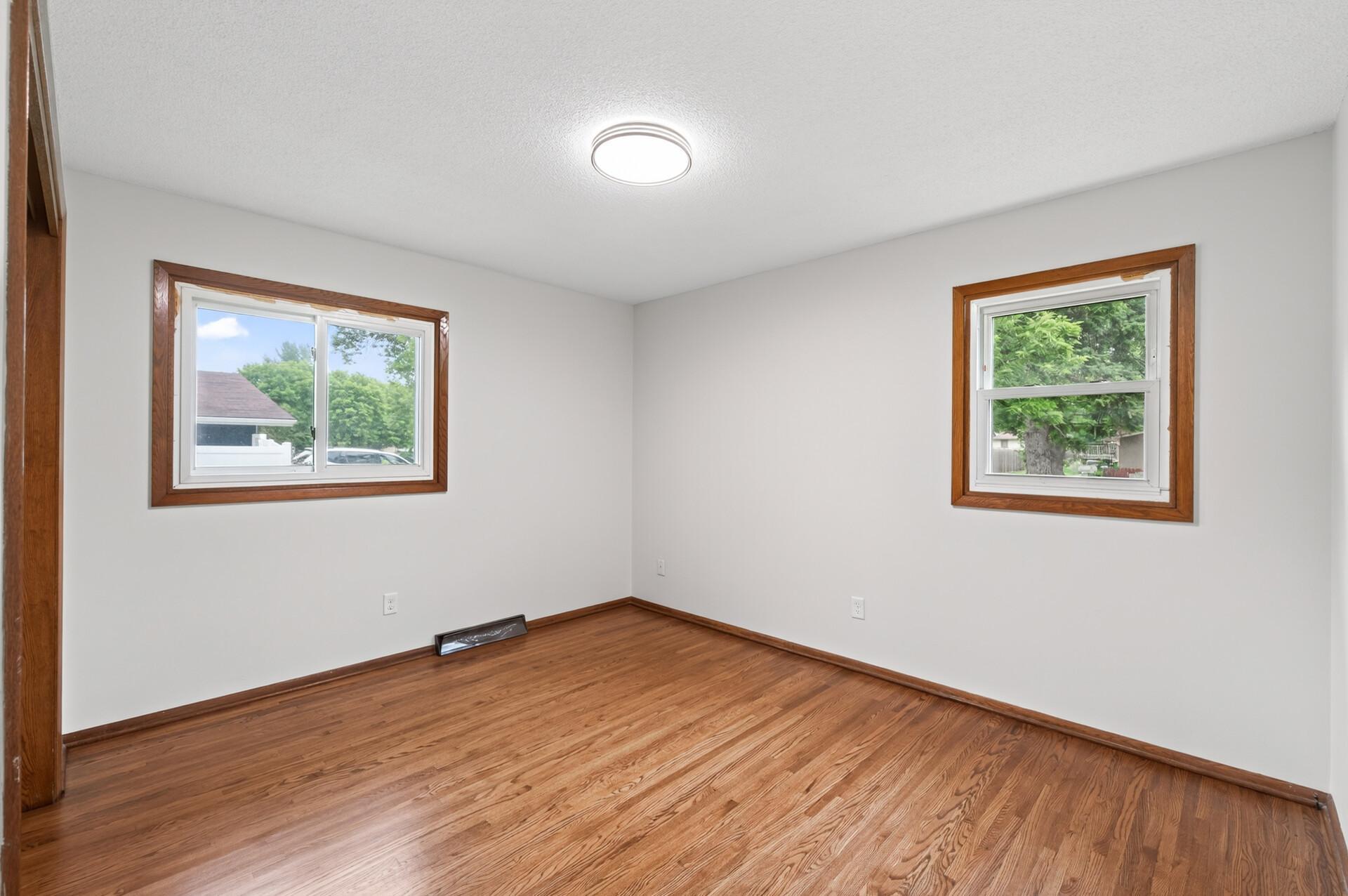 Primary bedroom offers natural light and charming hardwood floors.