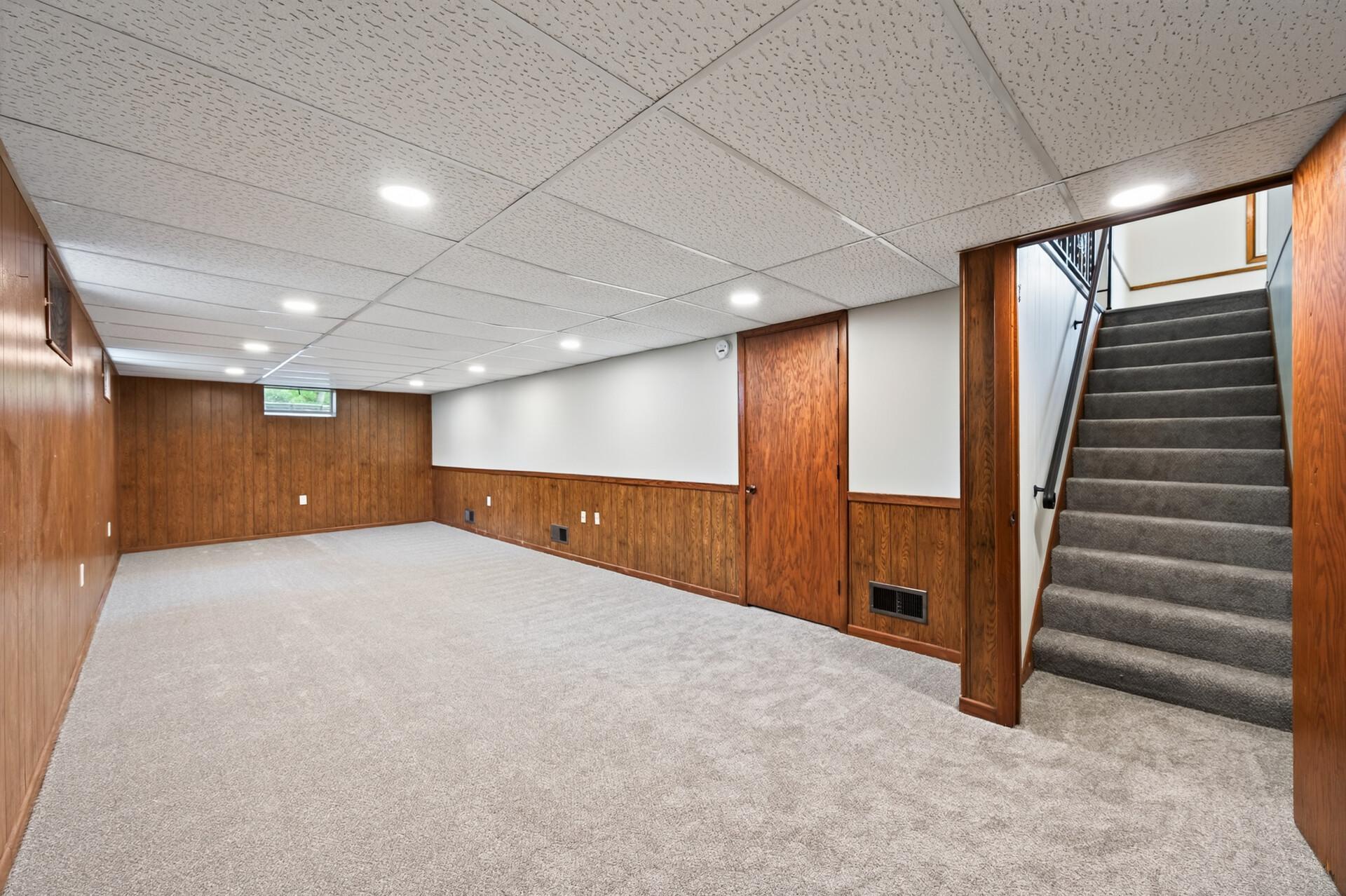 Expansive basement living area with new carpet offers endless potential.