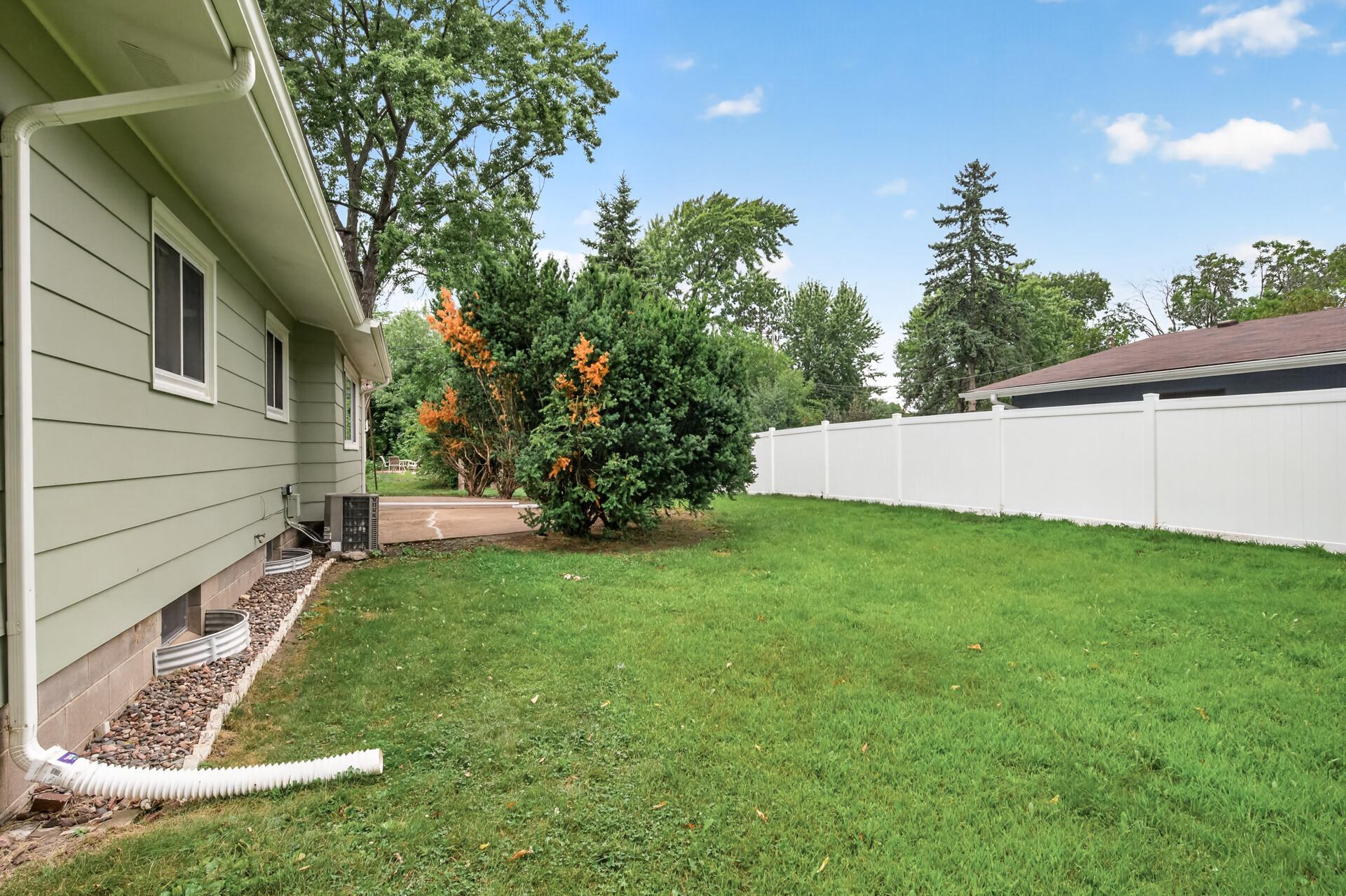 Rear exterior with lush yard and inviting outdoor spaces