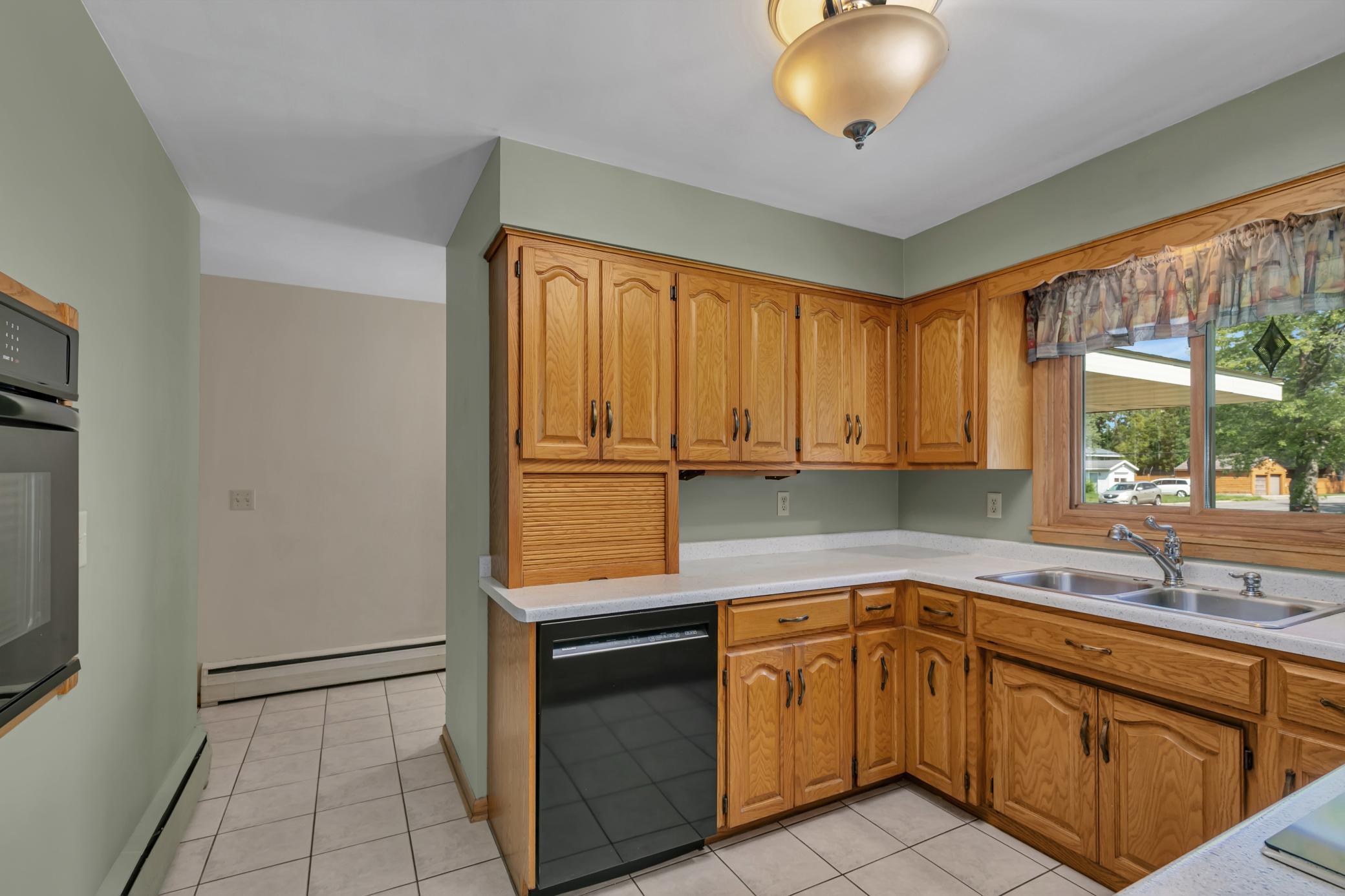 The kitchen also features tiled flooring, garbage disposal, and an updated light fixture. The dishwasher and wall oven are approximately seven years old.