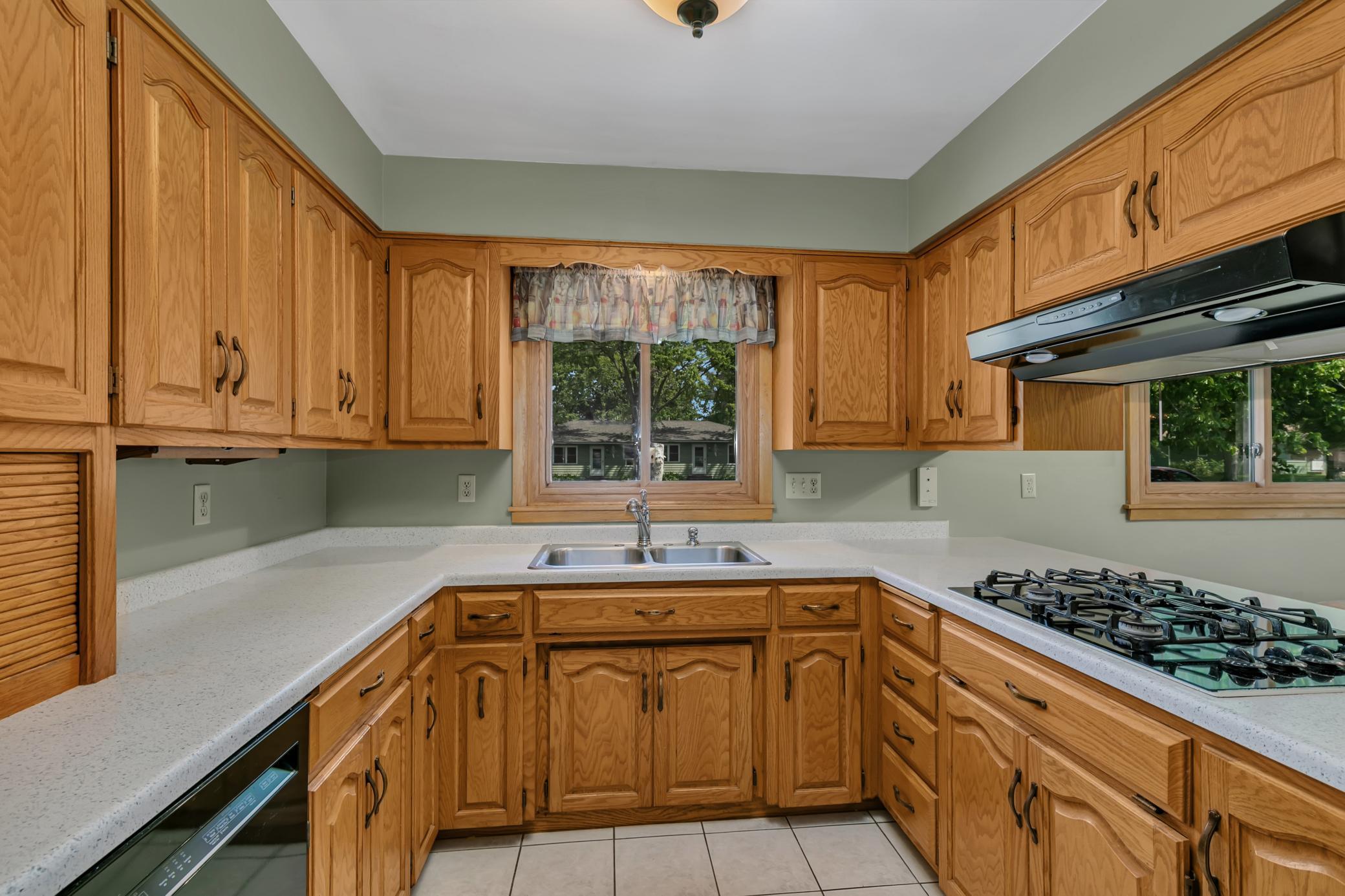 The kitchen offers a practical and inviting layout with cathedral-style raised oak cabinetry.