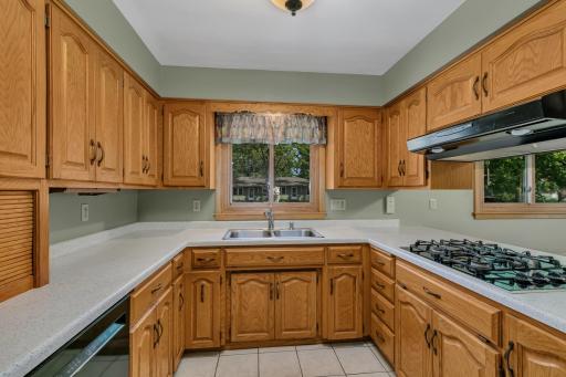 The kitchen offers a practical and inviting layout with cathedral-style raised oak cabinetry.