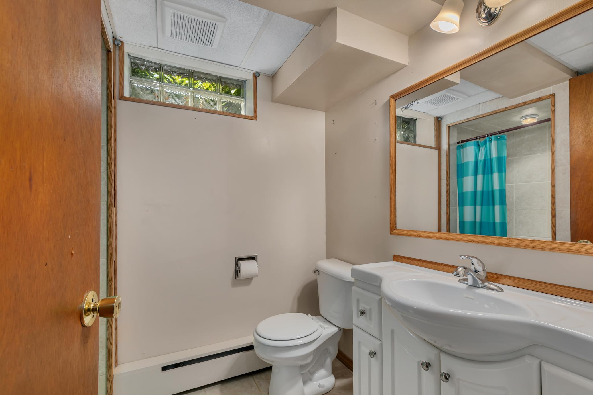 A three-quarter bathroom features ceramic tile flooring, a tiled shower surround, and a linen closet.