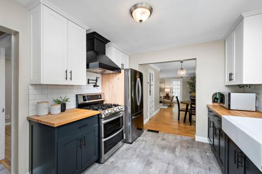Great kitchen enjoys stainless appliances, butcher block counters, ample cabinet and counter space, a pot filler at the stove, and a beautiful vent!