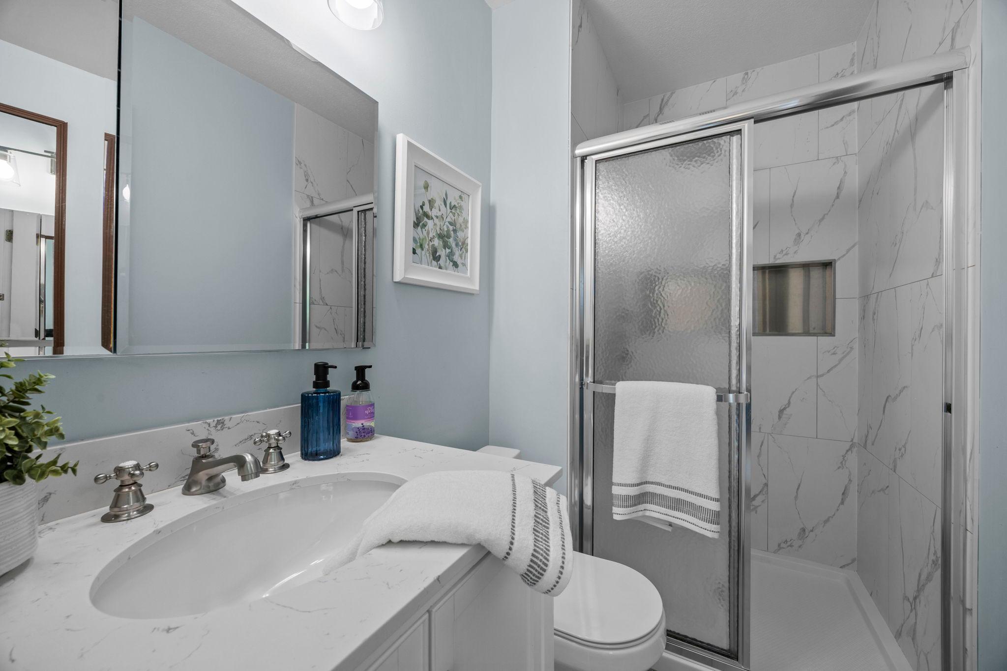 Updated in 2023, the ensuite includes a walk-in rain shower and vanity for additional storage,