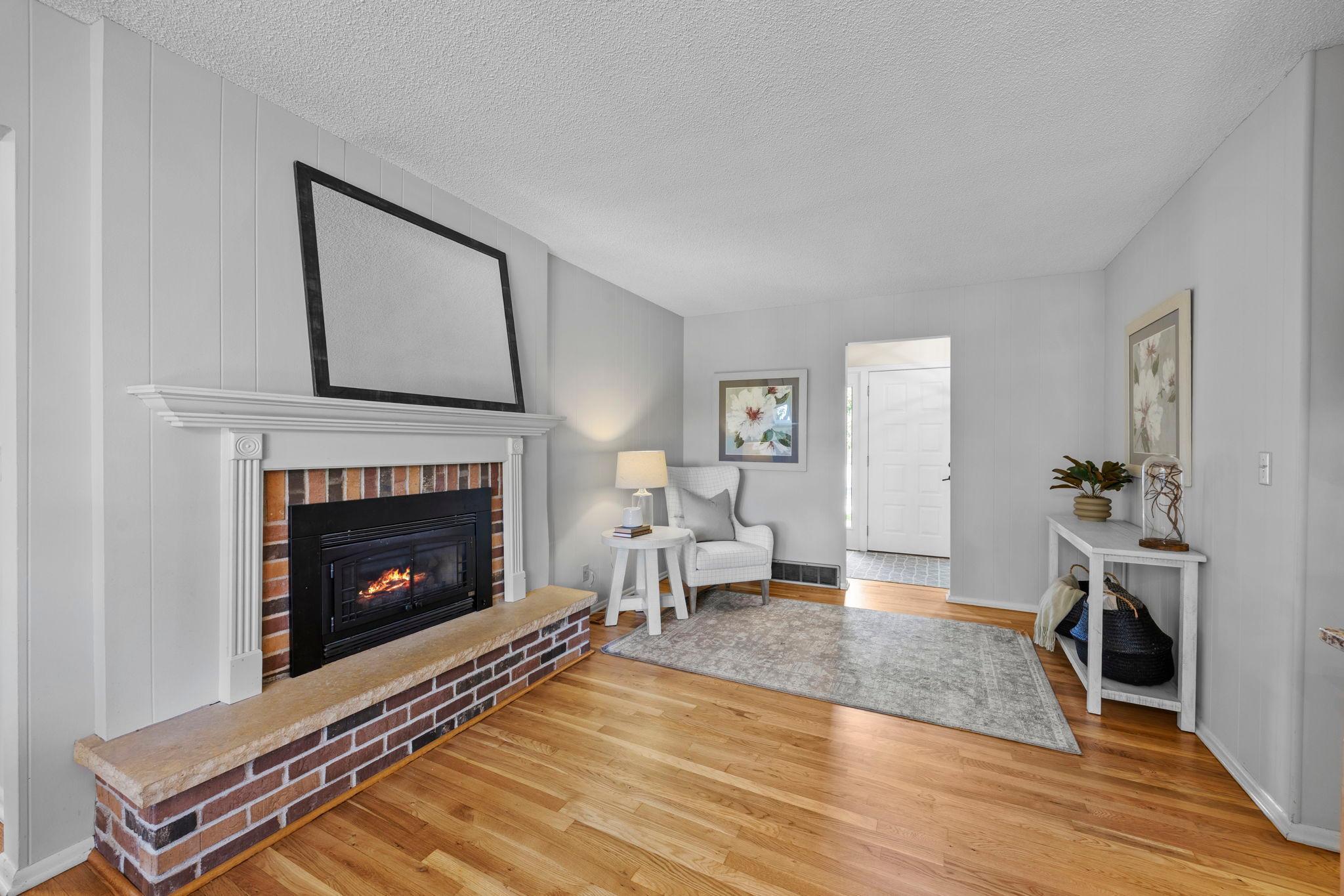 Complete with hardwood flooring and a gas fireplace surrounded by brick.