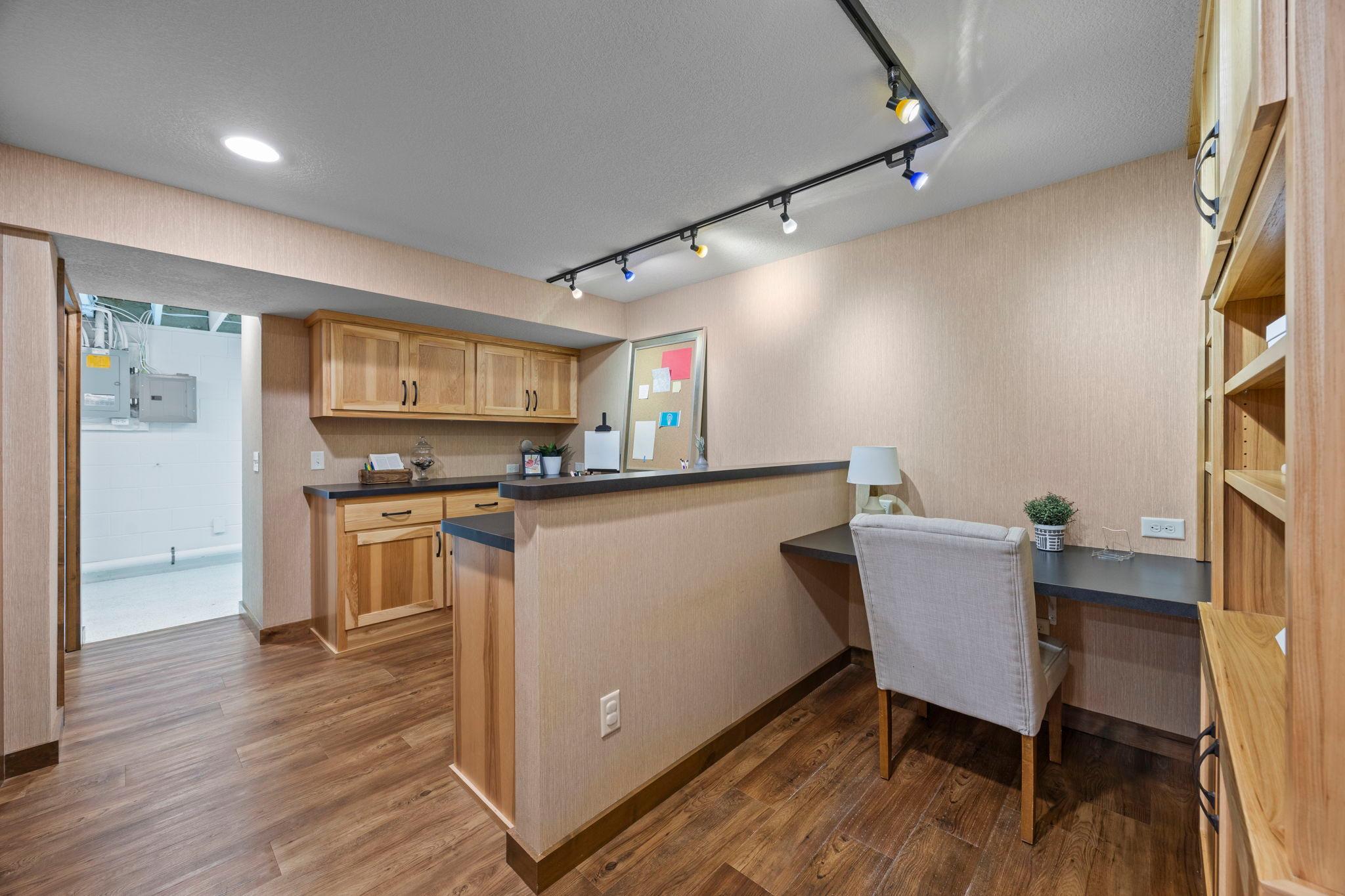 The large dedicated office features dual built-in desks, each with its own cabinetry, storage, shelving, and integrated outlets.