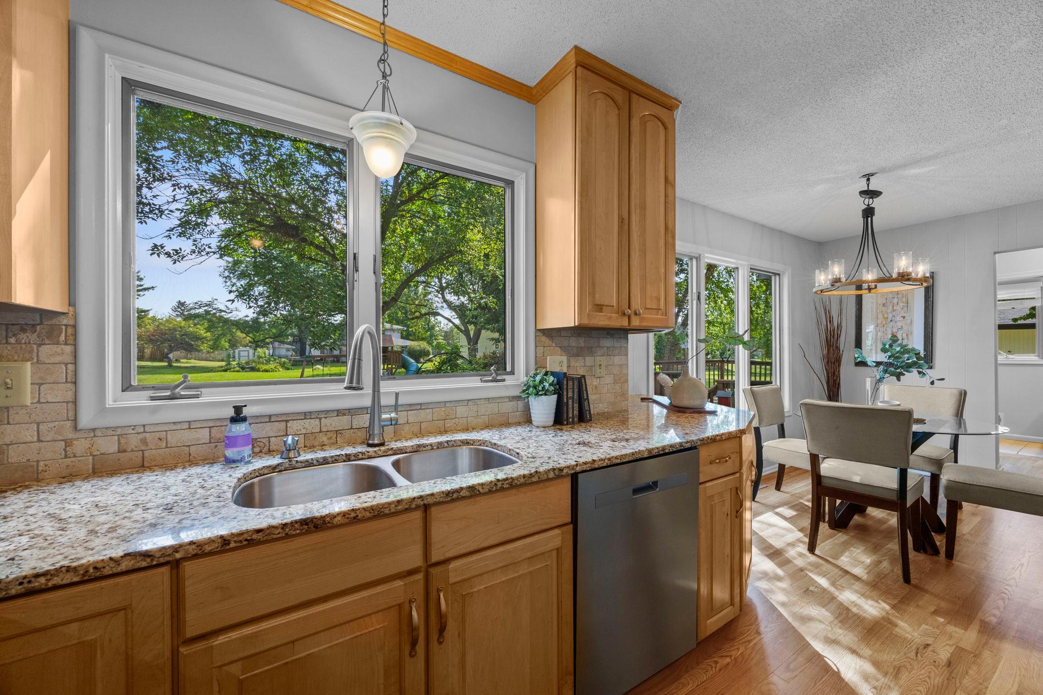 The beautiful kitchen features hardwood flooring and tile backsplash.