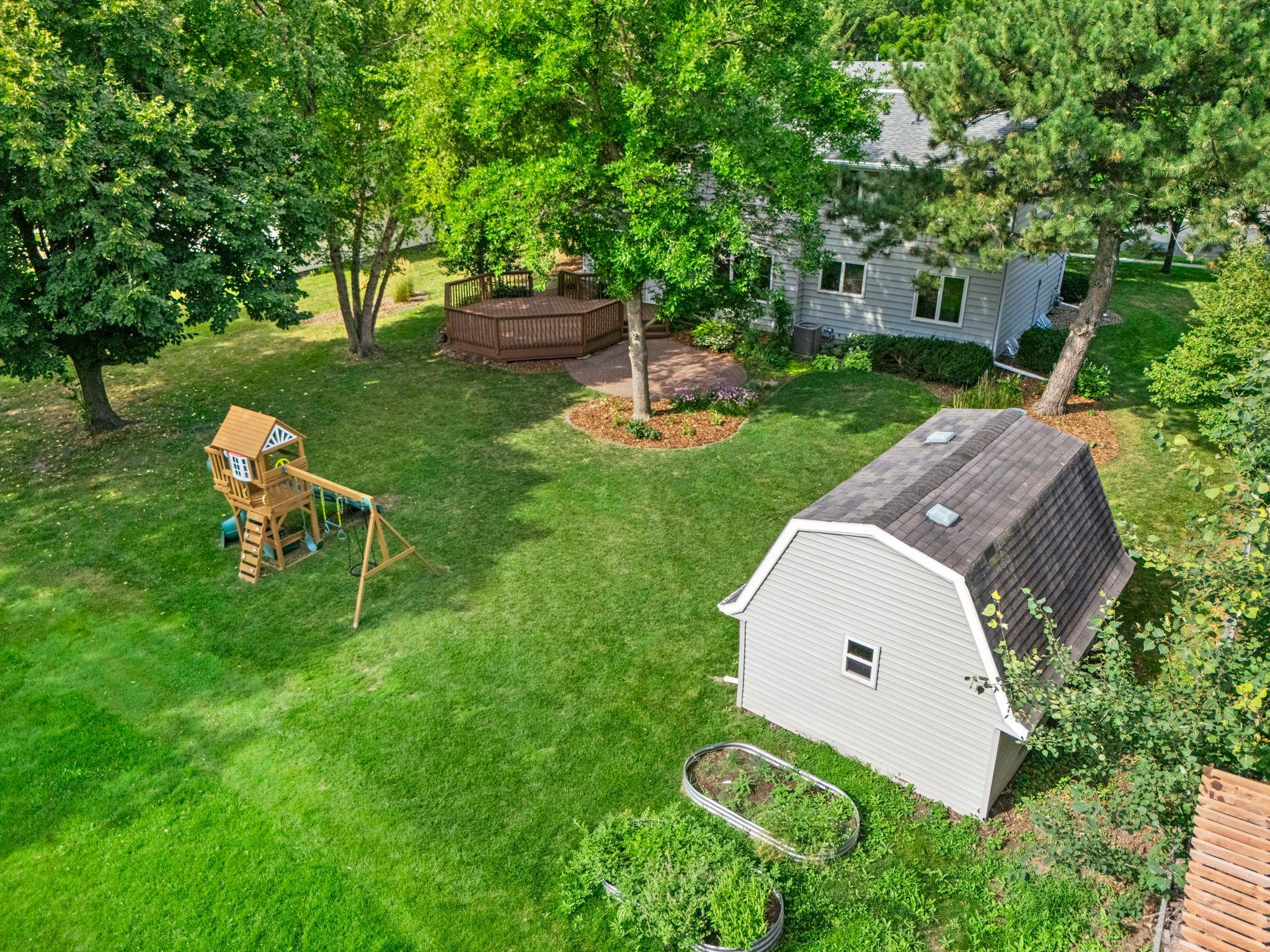 Playset, storage shed, and peaceful views of the greenery behind the home!