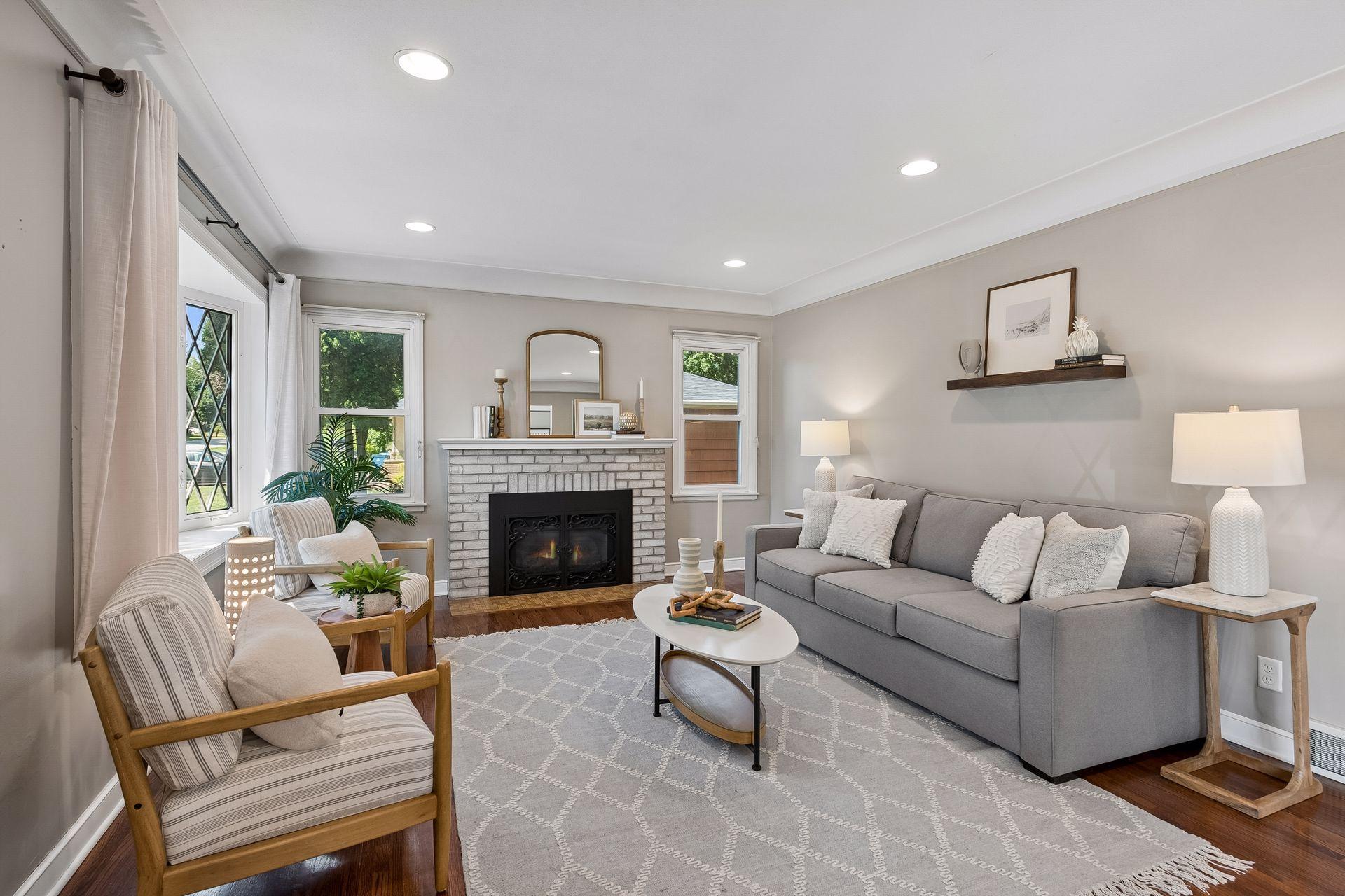 19x13 main-floor living room with a wood-burning fireplace, hardwood floors, and coved ceilings. South and west-facing windows.