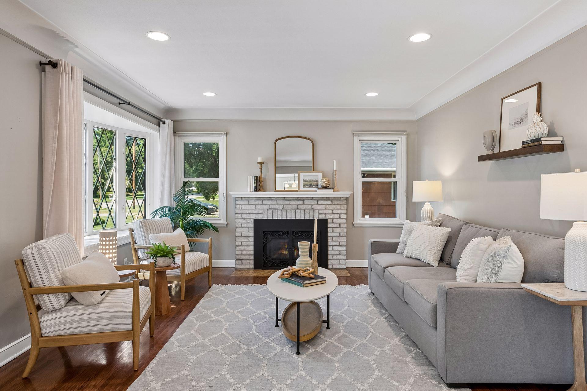 19x13 main-floor living room with a wood-burning fireplace, hardwood floors, and coved ceilings. South and west-facing windows.