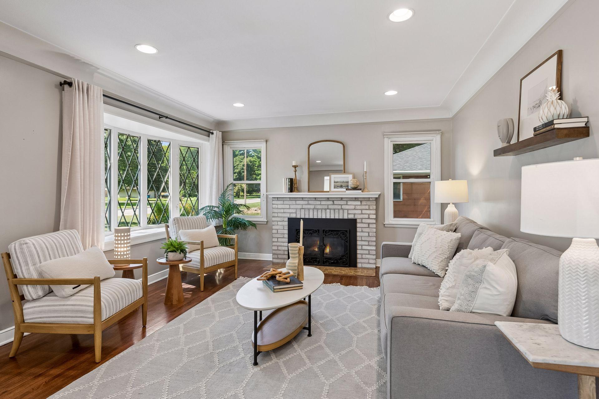 19x13 main-floor living room with a wood-burning fireplace, hardwood floors, and coved ceilings. South and west-facing windows.