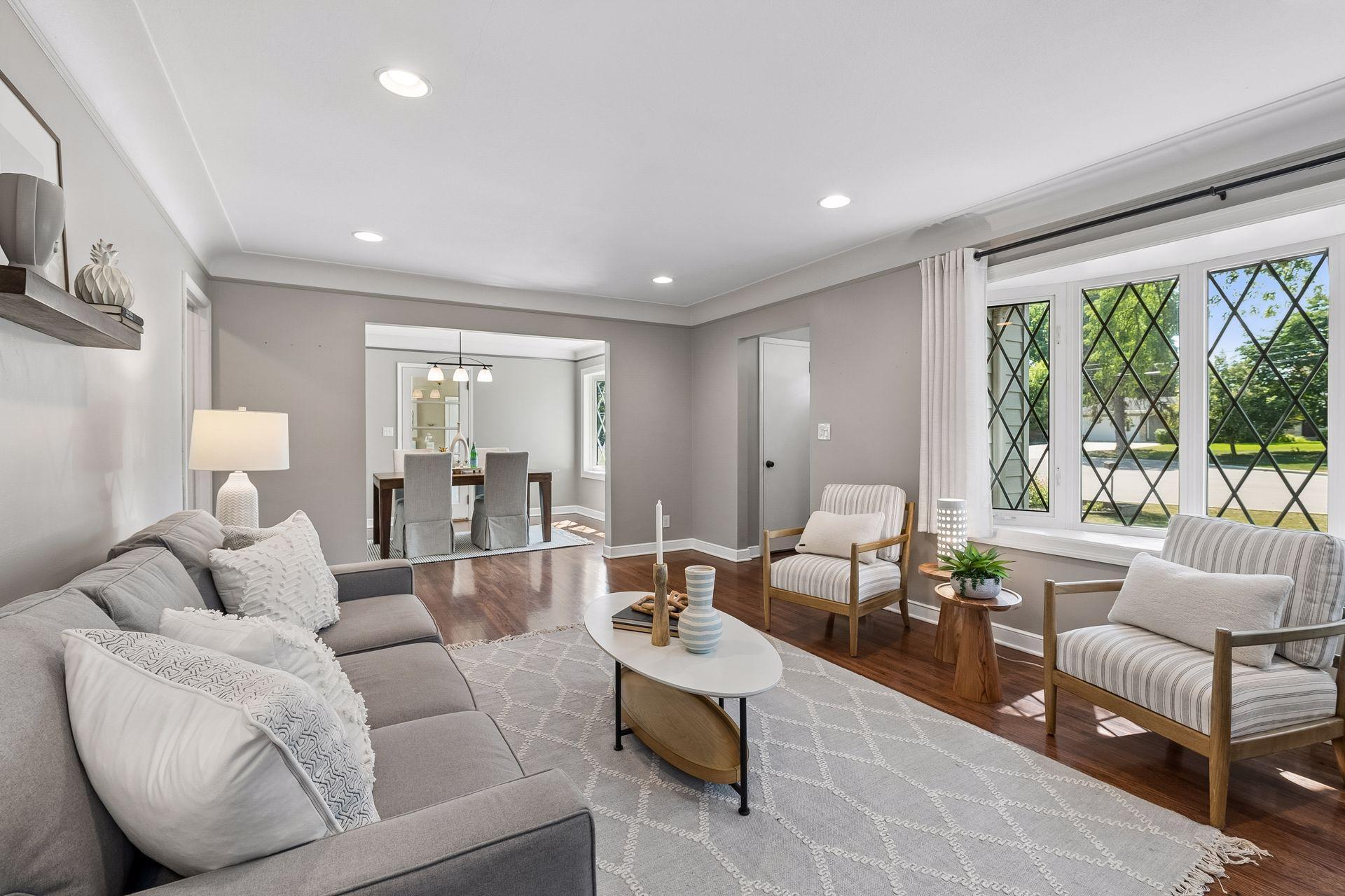 19x13 main-floor living room with a wood-burning fireplace, hardwood floors, and coved ceilings. South and west-facing windows.