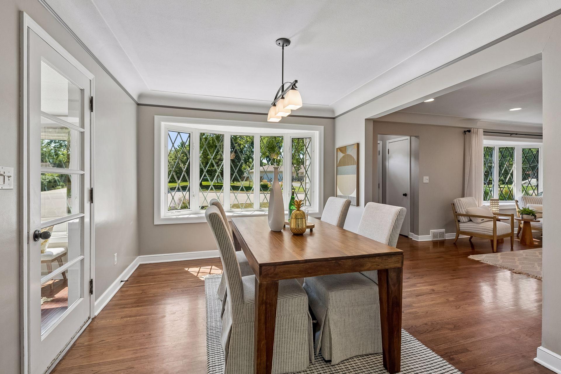 13x10 main-floor dining room with hardwood floors, white enameled trim, and coved ceilings. South-facing windows.