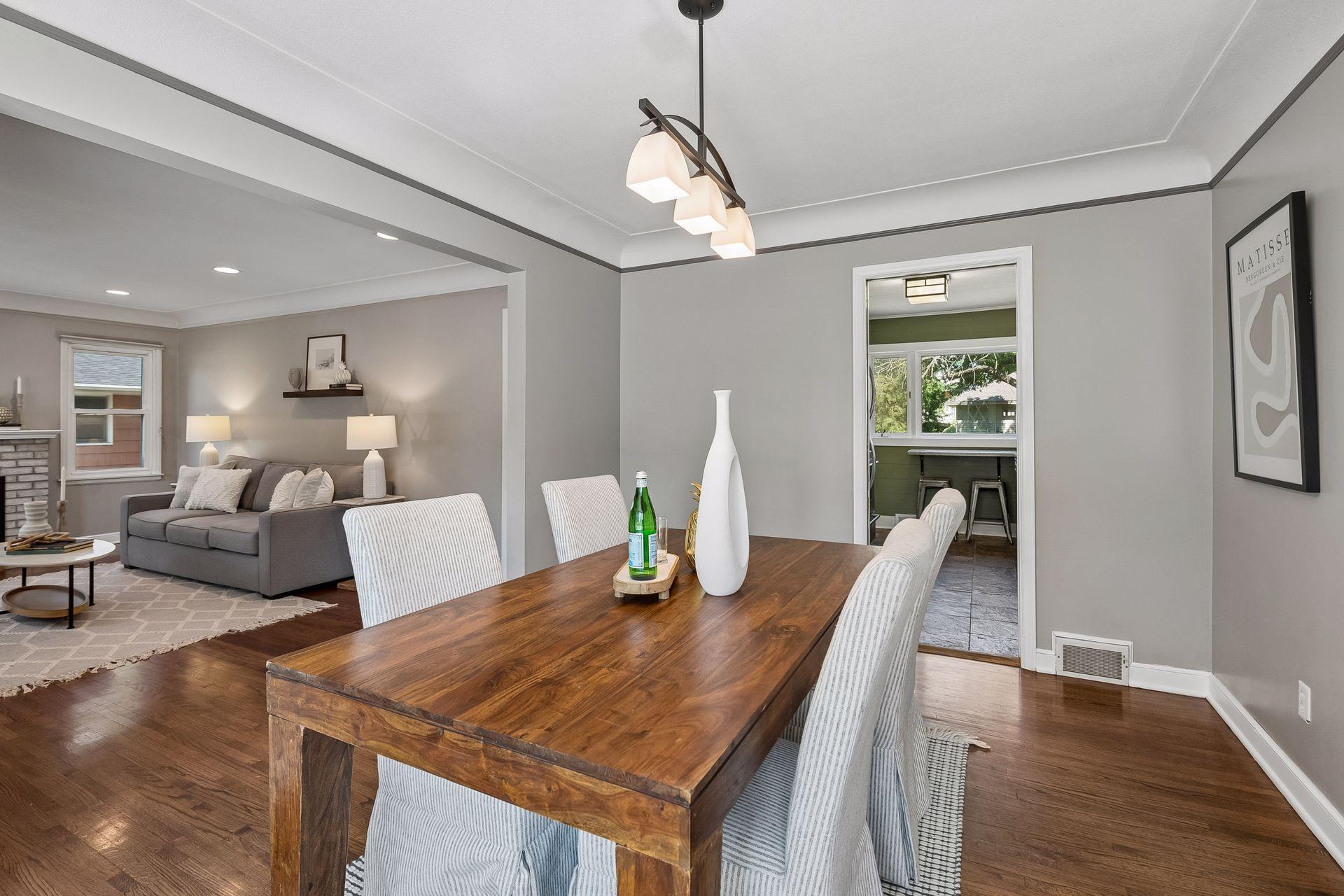 13x10 main-floor dining room with hardwood floors, white enameled trim, and coved ceilings. South-facing windows.