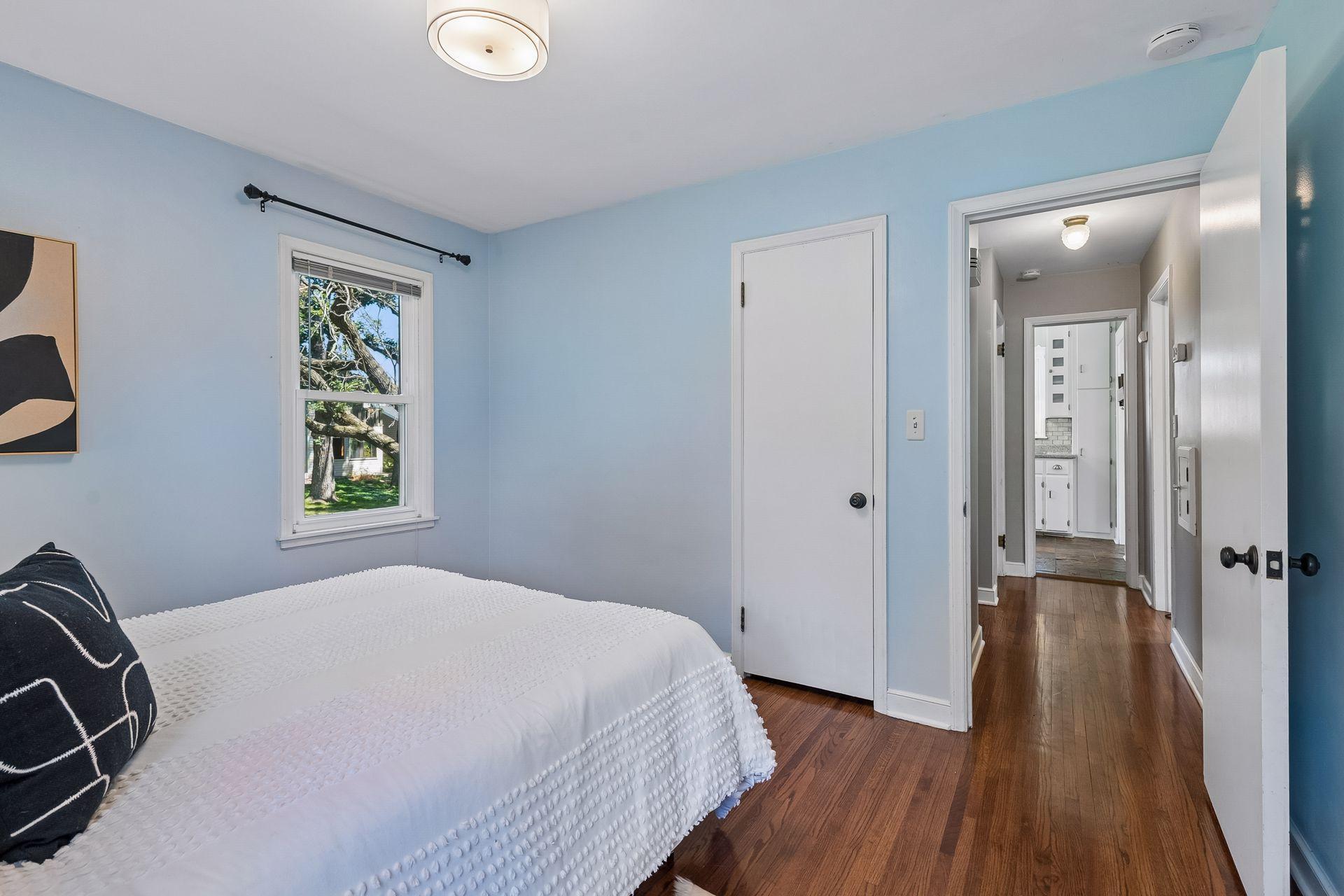 12x10 Main Floor Bedroom with White enameled Trim and Hardwood floors. North and west-facing windows.