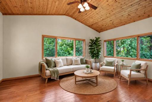 Beautiful, bright sunroom leads to a deck with view of the private backyard- VIRTUALLY STAGED