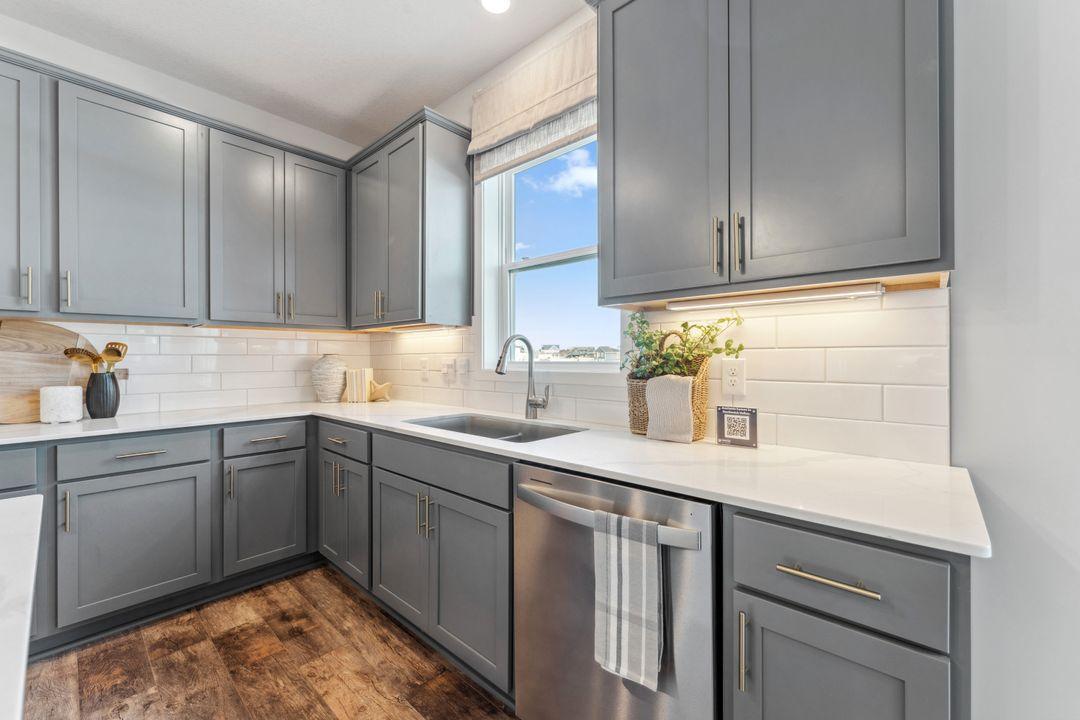 Undermount sink and pull out faucet make clean up a breeze. Photo of model home, colors and finishes are similar.
