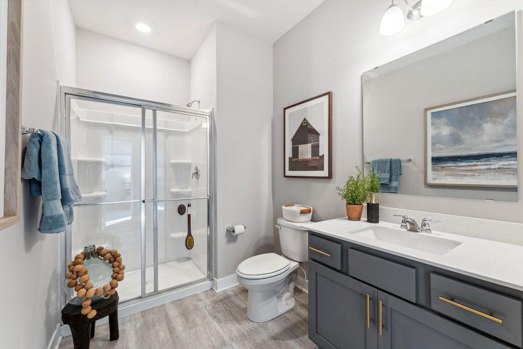 You'll find two baths on the main floor. This 3/4 bath is adjacent to the 5th bedroom. What a perfect suite for visitors! Photo of model home, colors and finishes are similar.