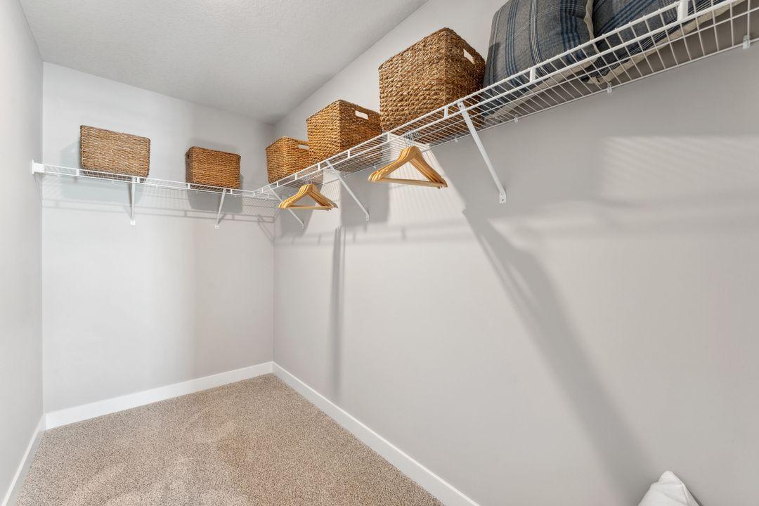 The large walk in closet in the secondary suite upstairs. Photo of model home, colors and finishes are similar.