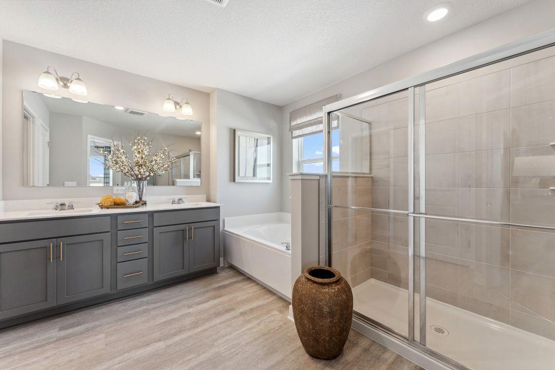 Walk in shower, soaking tub, dual sinks, and private water closet complete the primary bathroom. Photo of model home, colors and finishes are similar.