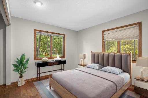 Virtually staged primary bedroom on upper level bedroom. One of three bedrooms on the this level all with hardwood floors. Primary bedroom walkthrough to full bathroom.