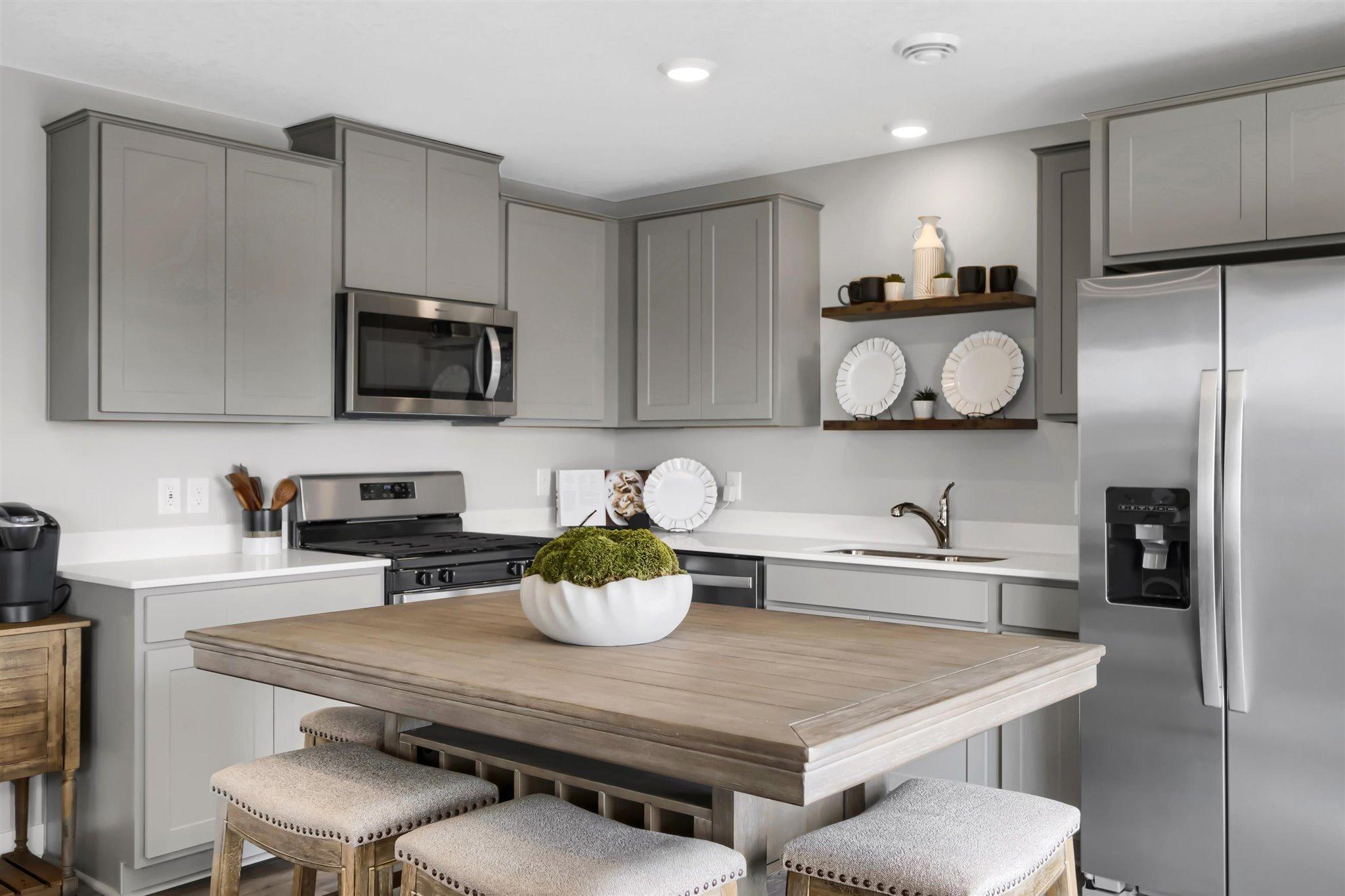 Thoughtfully designed kitchen with stainless appliance package including gas range, dishwasher and vented micro-hood. (Model photo, colors may vary)