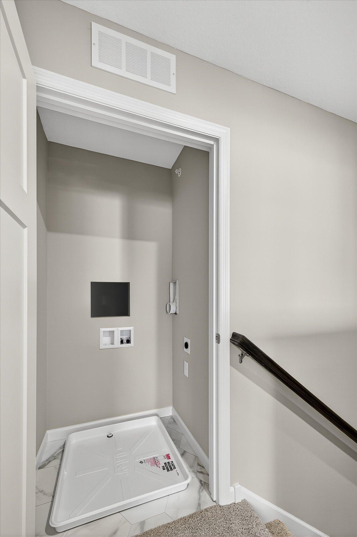 A dedicated laundry closet is ready for stacked washer and dryer appliances, keeping laundry convenient without taking up valuable living space.