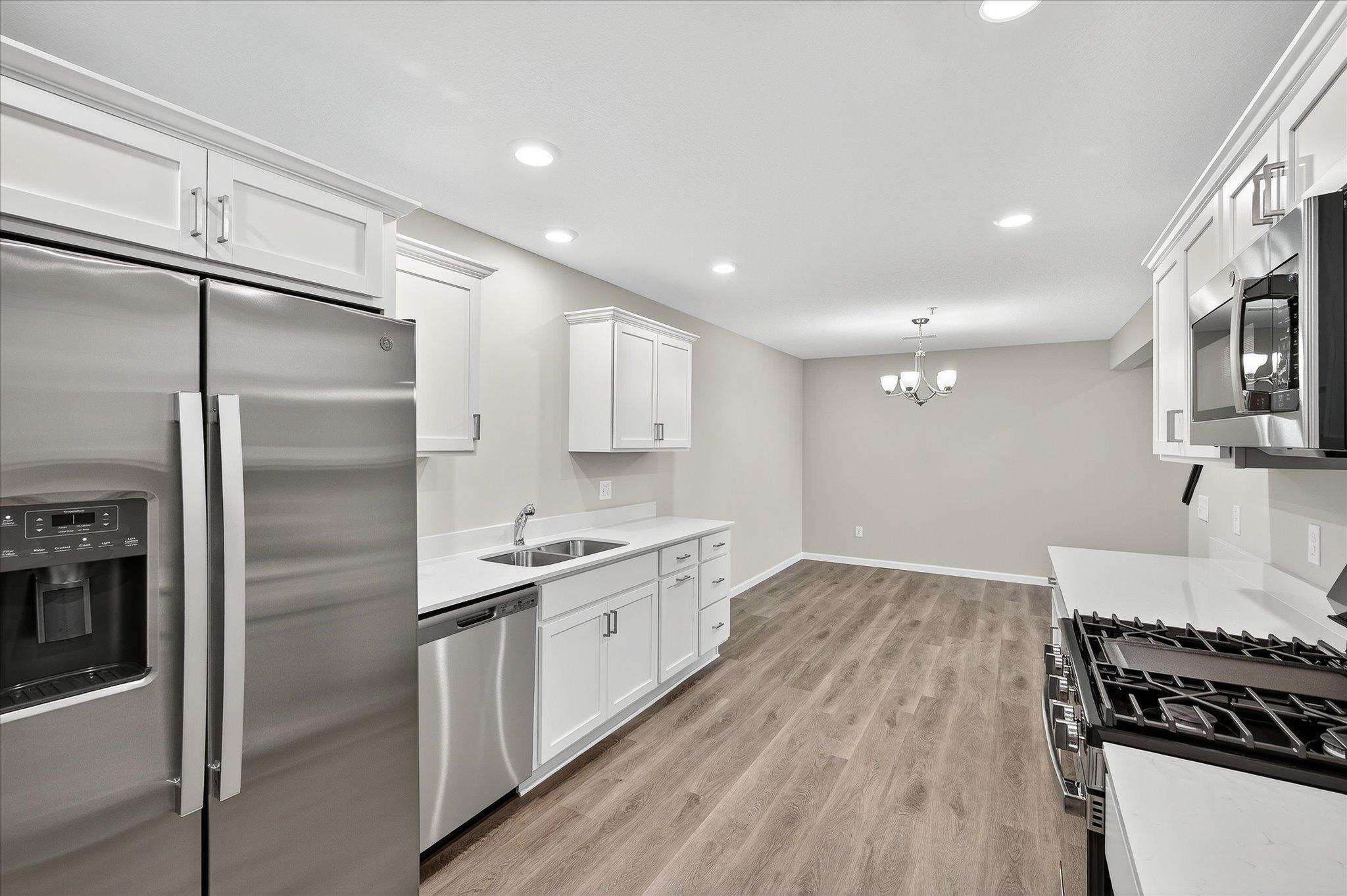 Painted cabinetry, crown molding, hardware, and stainless steel appliances create a clean, polished look.