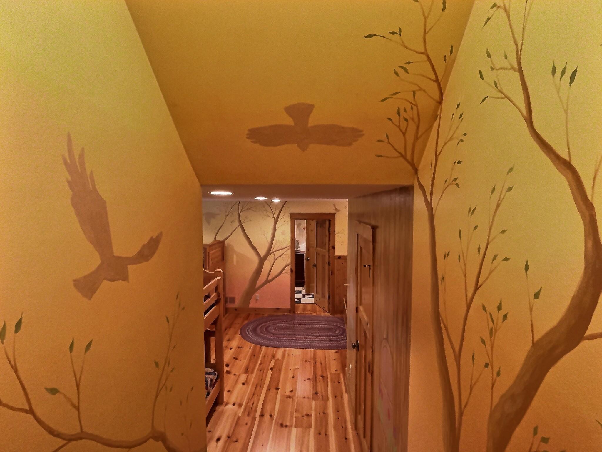 View of the hallway leading to the expansive bunk-room. The walls are intricately hand painted throughout the space.