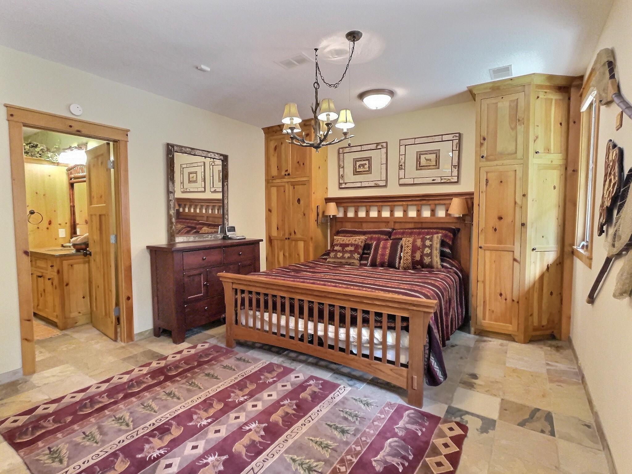 Large lower level bedroom boasts tile flooring, built-in cabinets, lake views and private bathroom.