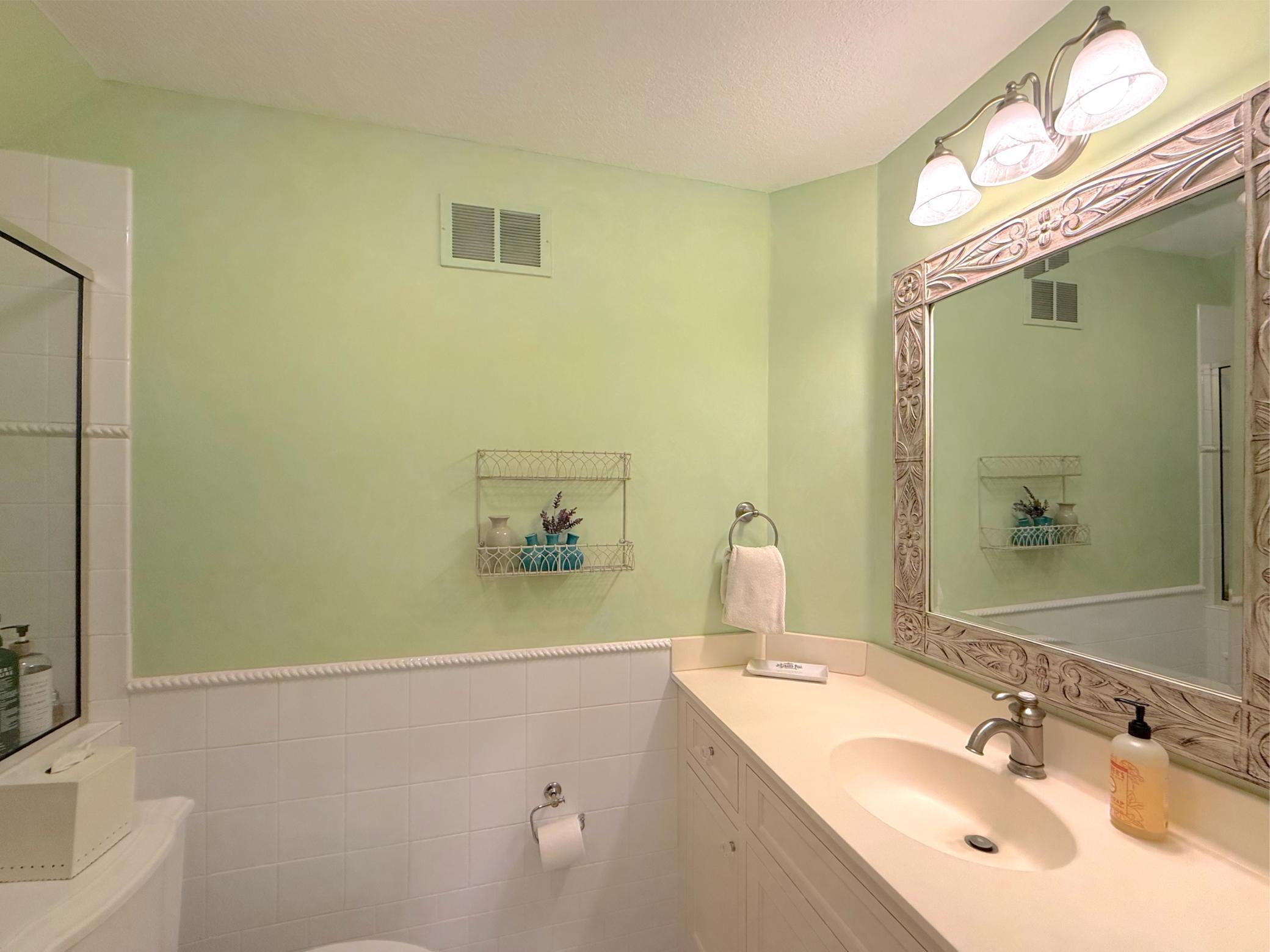 This lovely private three-quarter bathroom includes tile surround, custom cabinet, glass shower and upper-end fixtures.