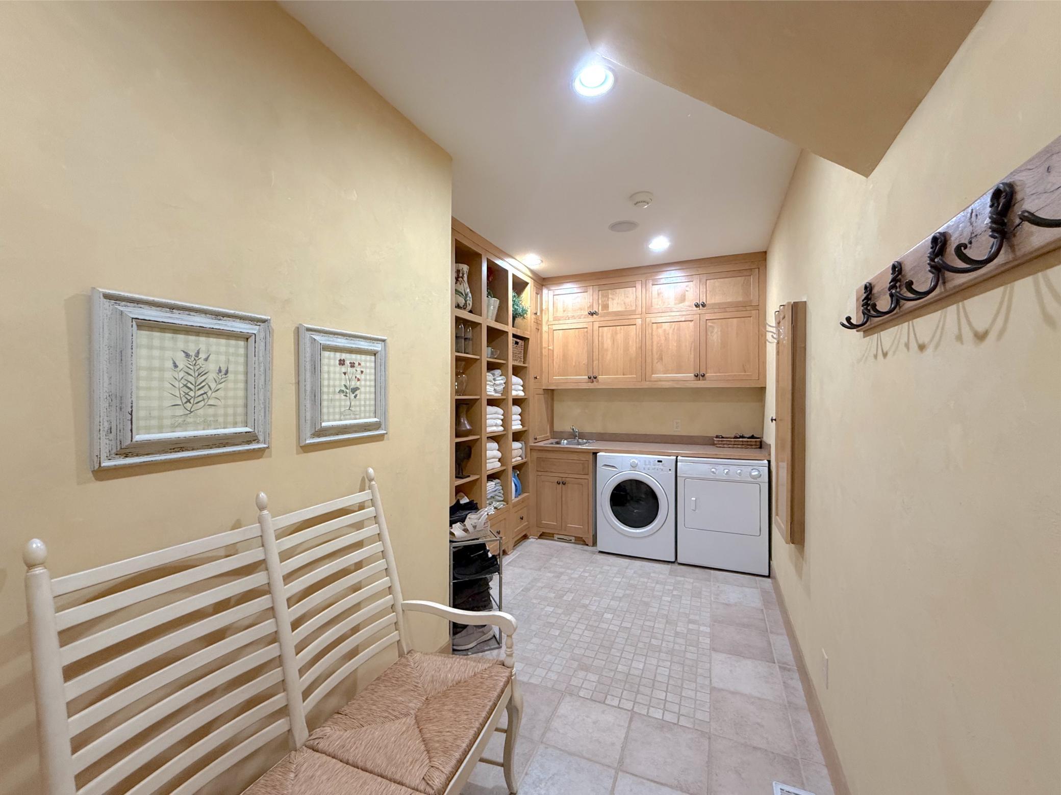 The main level laundry/mud room includes tile flooring and tons of cabinet & shelving space and opens to the garage.