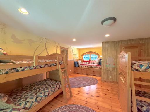 This charming bunk-room with full mural walls also includes a built-in bed with a custom pull out bed finished with a window.