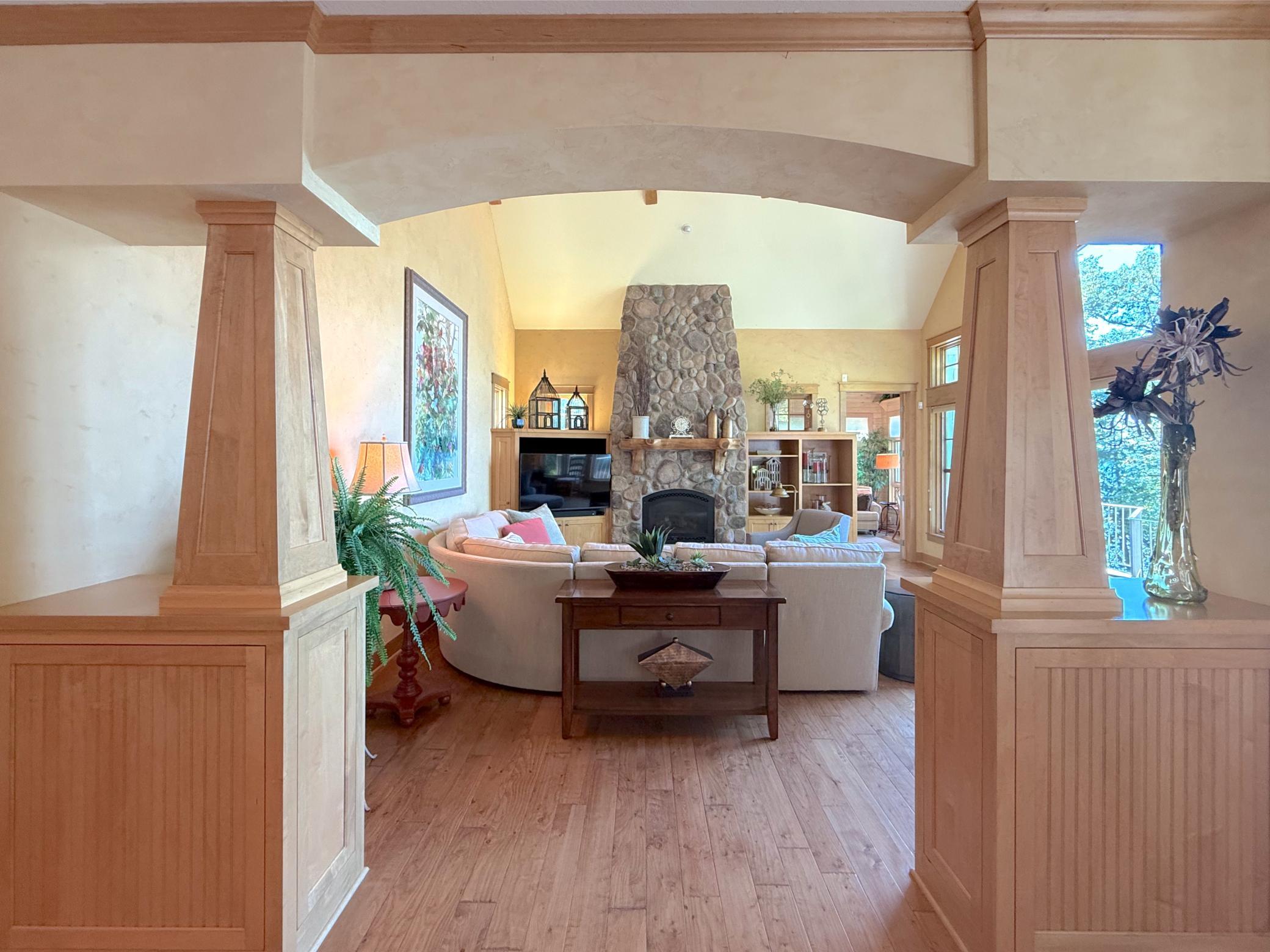 View of the living room from the dining room through a gorgeous custom built archway that sets the tone for the expansive space.