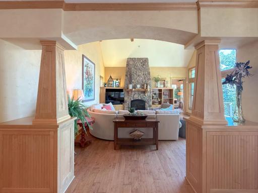 View of the living room from the dining room through a gorgeous custom built archway that sets the tone for the expansive space.