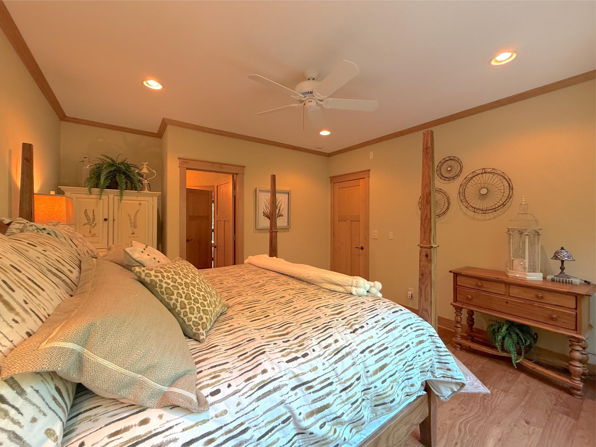 This main level bedroom is finished with a ceiling fan, wood flooring and warm wood accents - it's certainly a comfortable space.