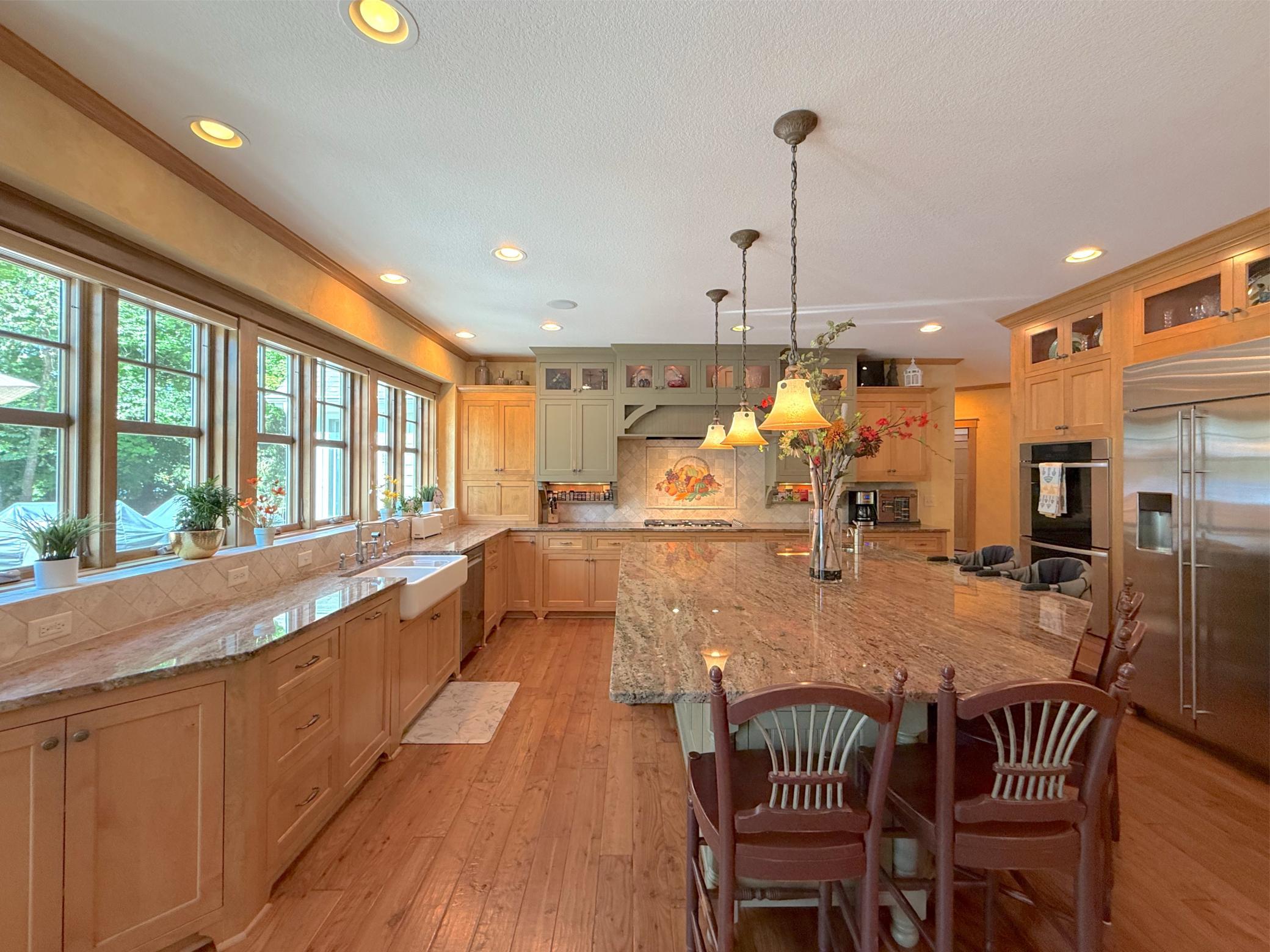 The center island includes an additional sink, pendant lighting, storage space and one of the best spots to enjoy lake views!