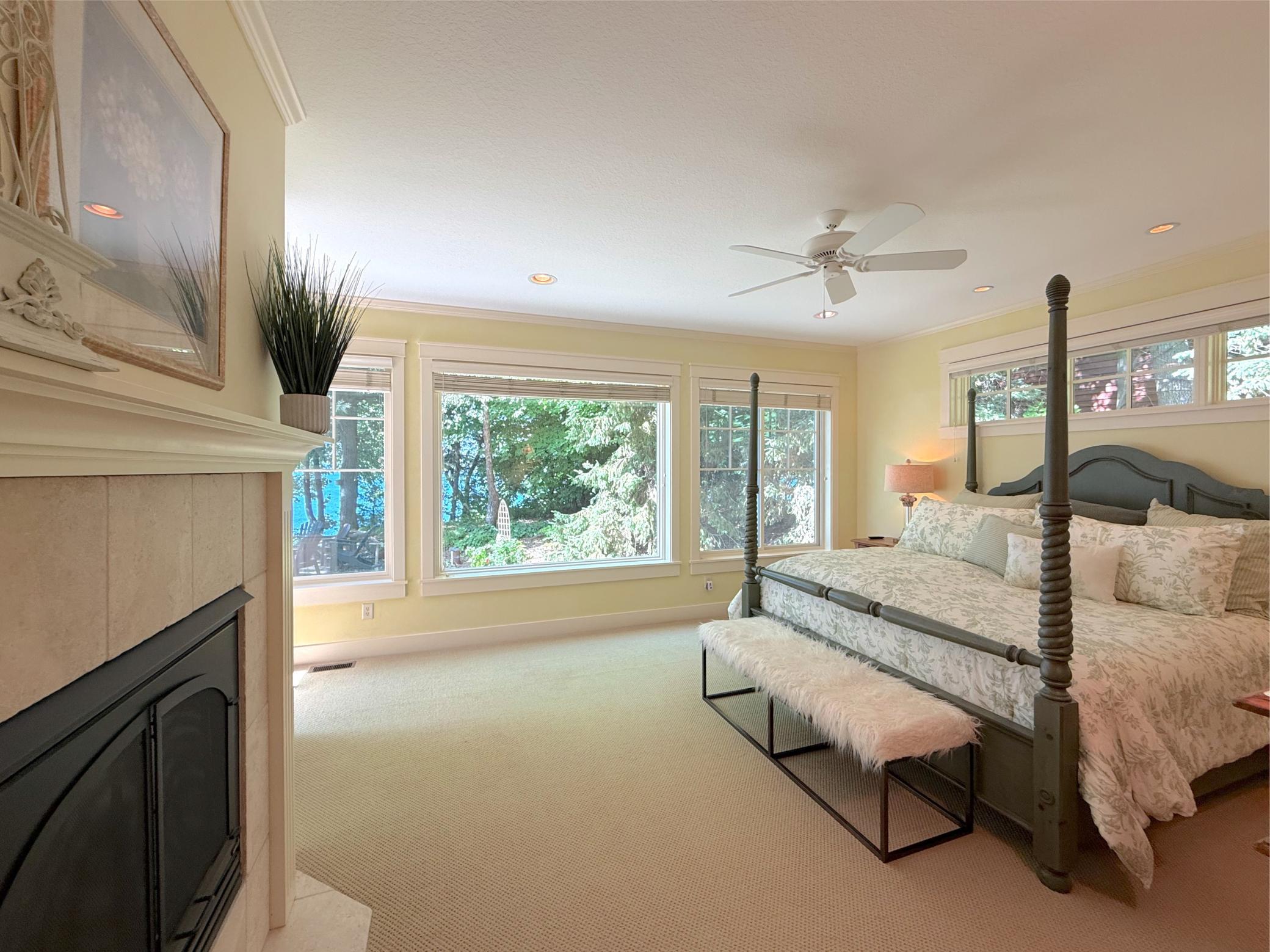 Appreciate stunning shoreline views and natural lighting offered by a wall of glass in this gorgeous private primary suite.