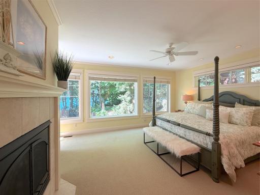 Appreciate stunning shoreline views and natural lighting offered by a wall of glass in this gorgeous private primary suite.