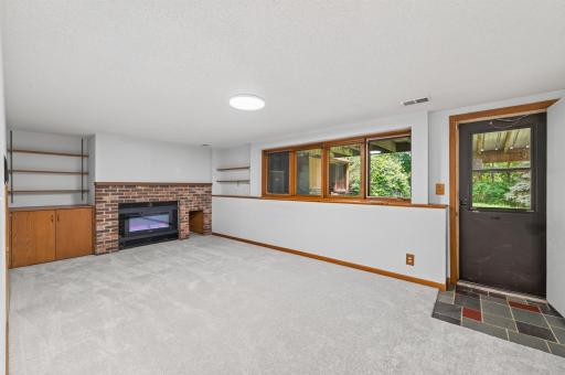 Lower level family room with fireplace and built-in shelving. Walks out to private backyard!