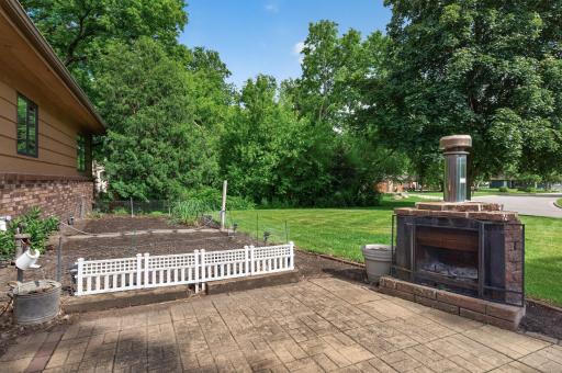 Outdoor wood-burning fireplace and brick paver patio is the perfect space to set up some chairs and make some s'mores!