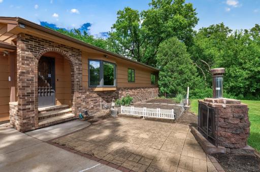 Outdoor wood-burning fireplace and brick paver patio is the perfect space to set up some chairs and make some s'mores!