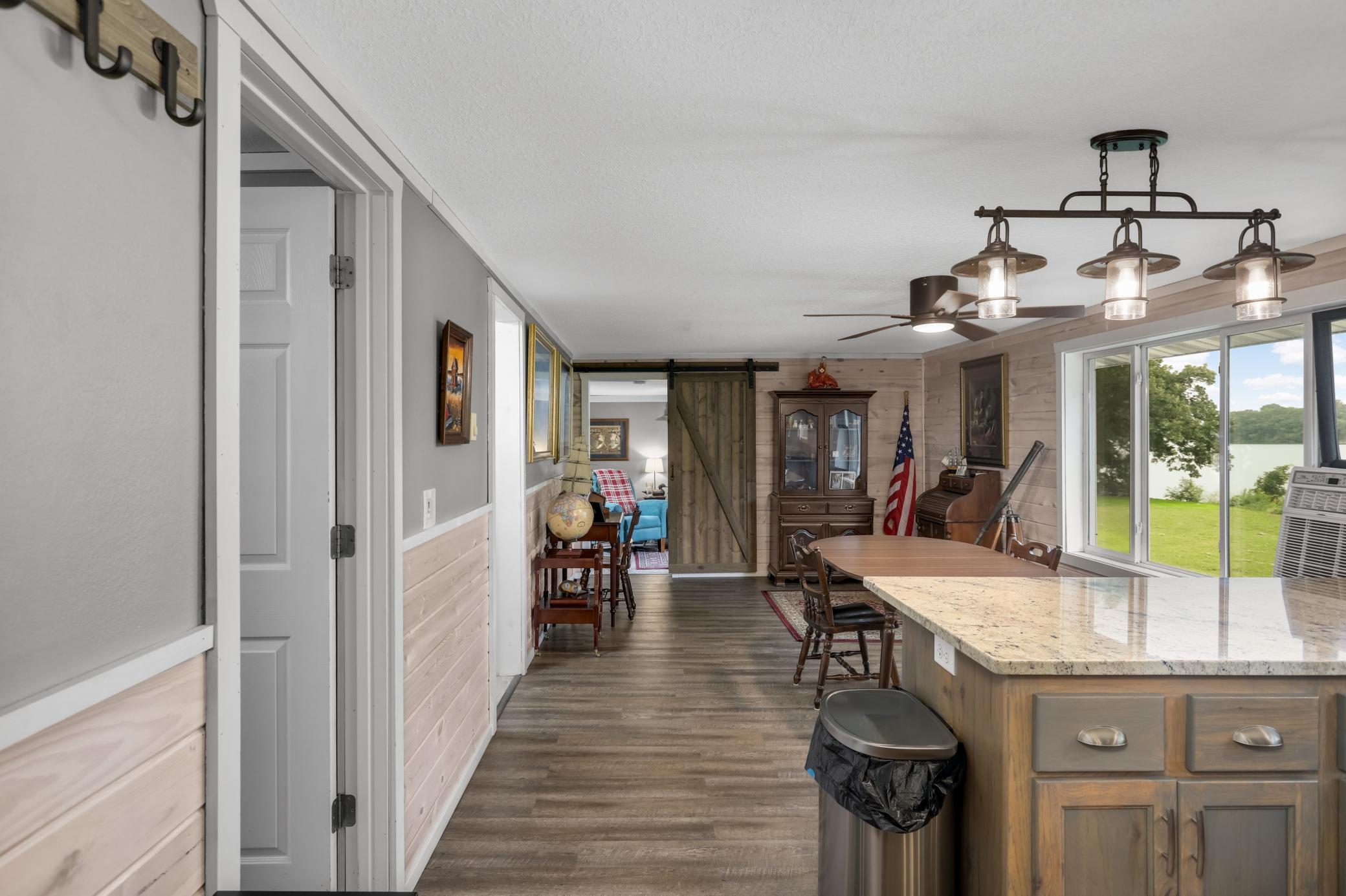 Open floor plan with luxury vinyl plank flooring and updated light fixtures.