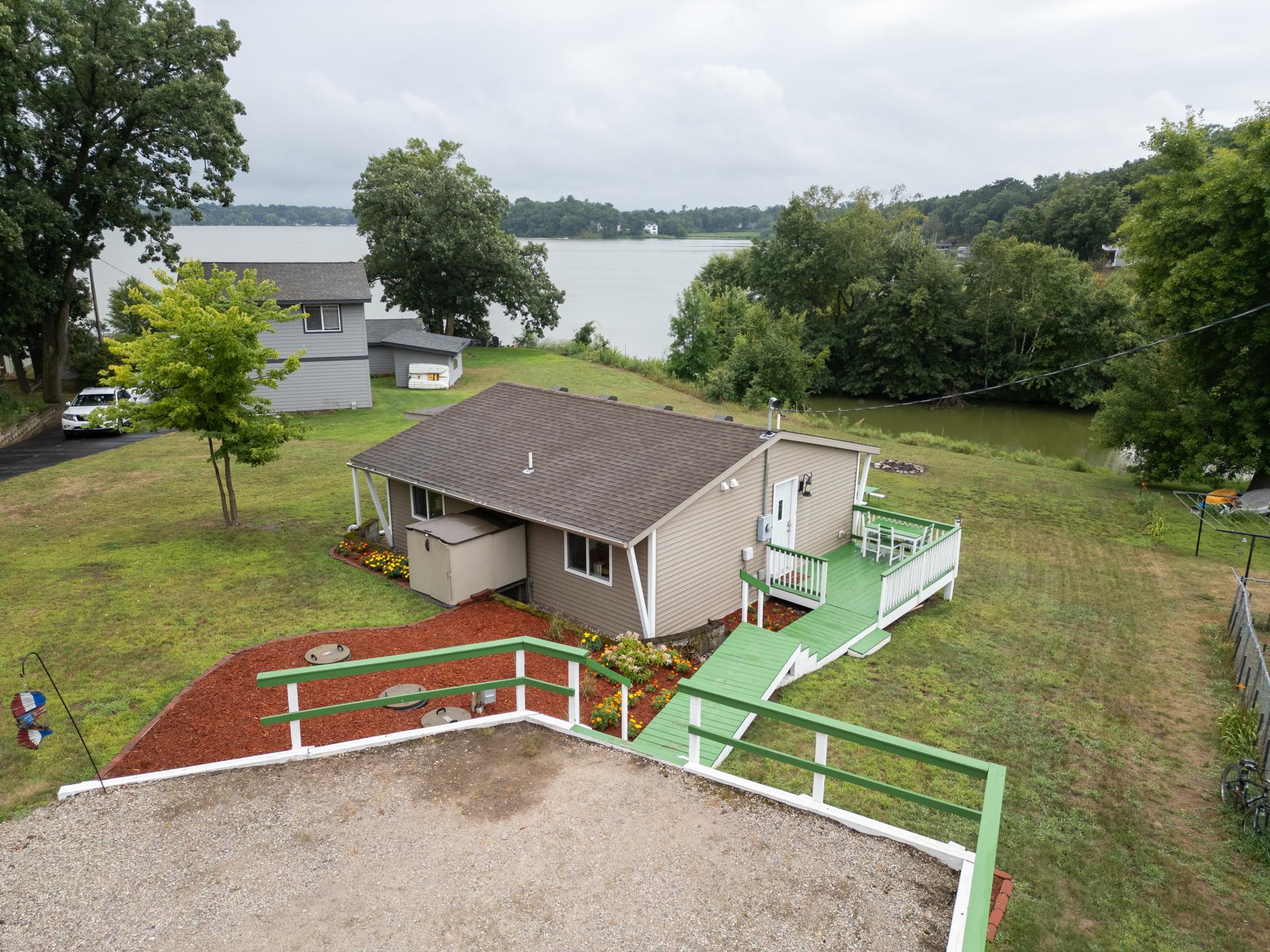 View from gravel parking driveway with stairs down to the home.