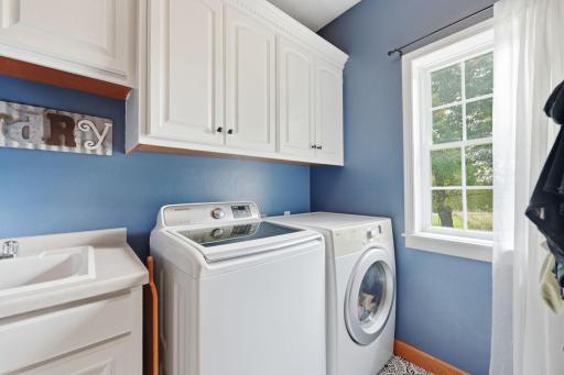 Convenient main floor laundry featuring a sink and storage space.