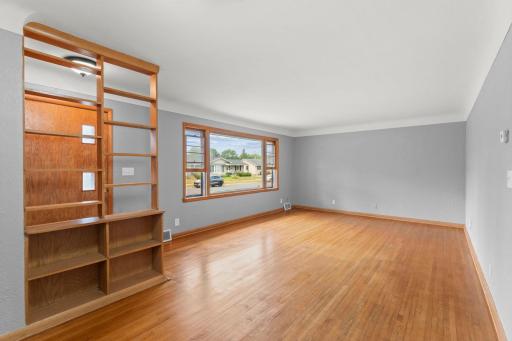 Bright living room with gleaming hardwood floors and a picture window bringing in great natural light.